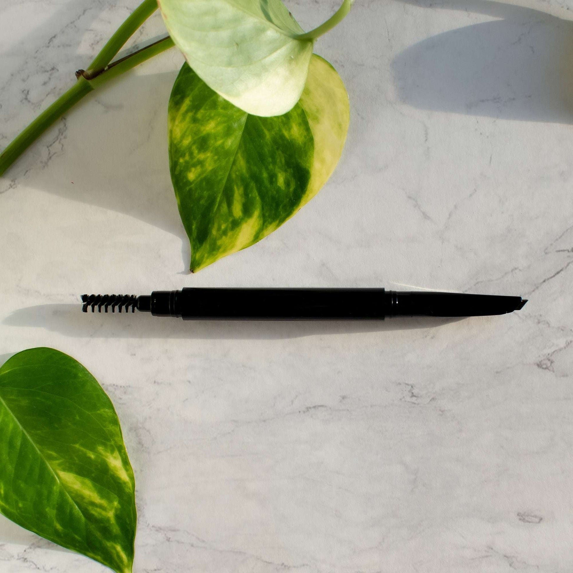 Dual tip brow pencil in charcoal shown at an angle for precise application